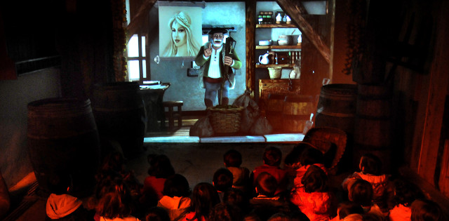 Niños sentados viendo en una pantalla la película de la leyenda del Olentzero