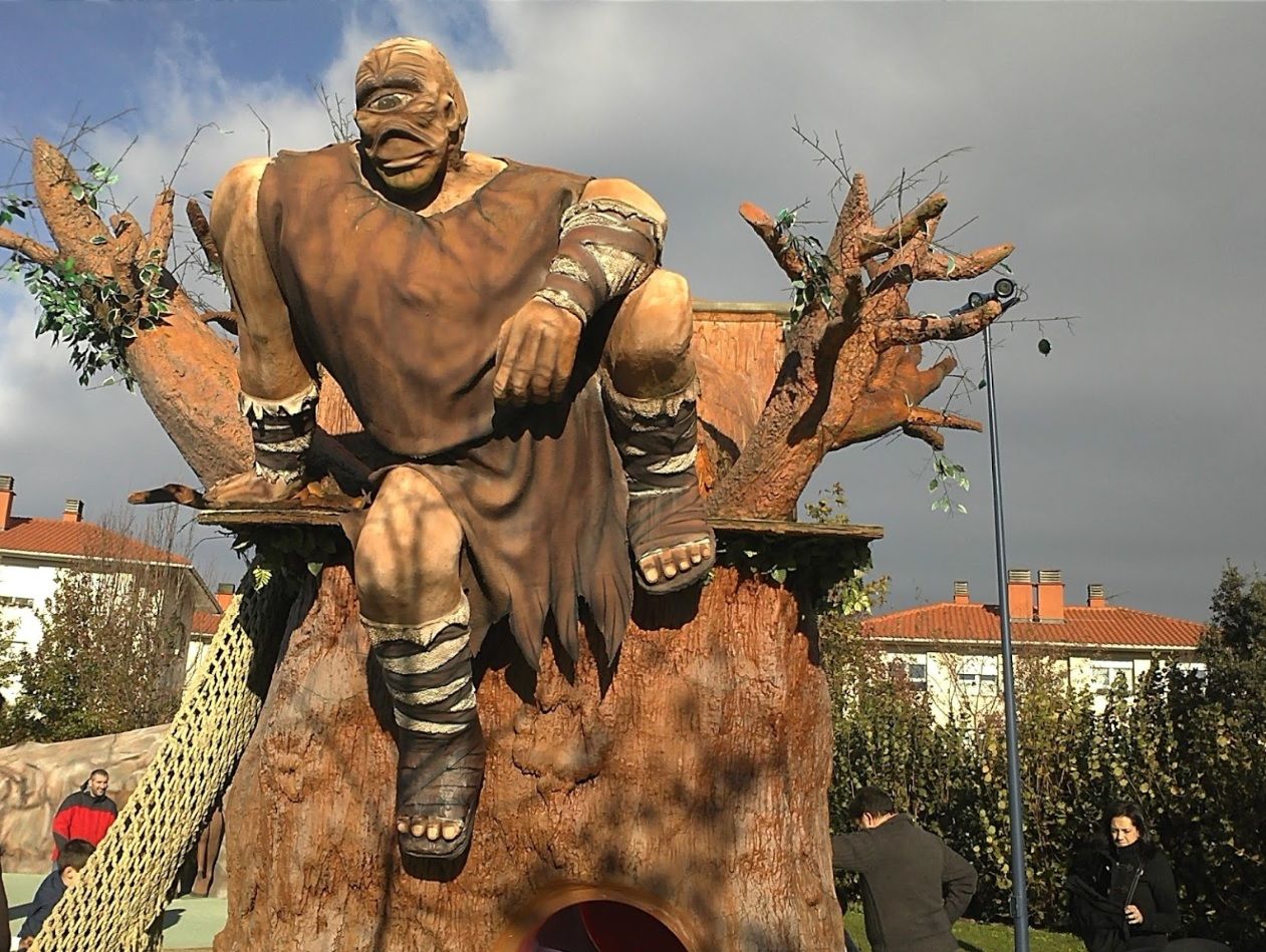 Figura de Tartalo, el gigante de un solo ojo, sentado sobre el árbol del tobogán en la casa del Olentzero